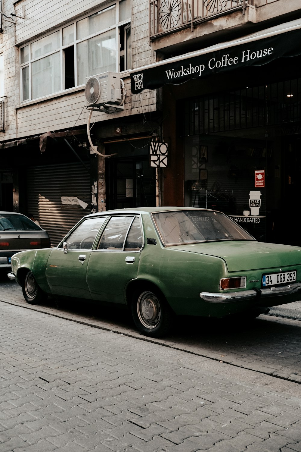 a green car parked on the side of a street