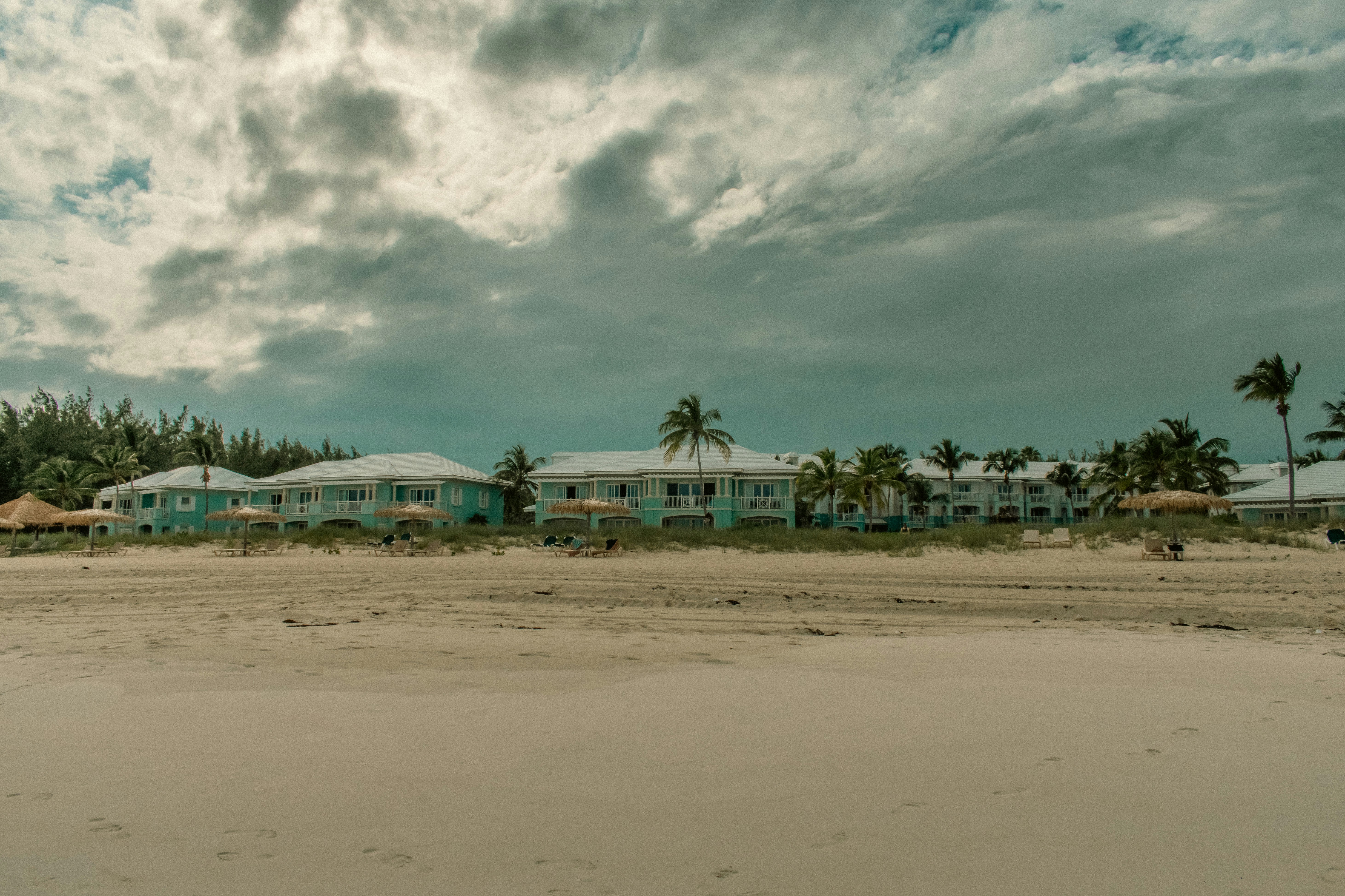 a beach with buildings and trees, Shot in Exuma, The Bahamas on a beach.