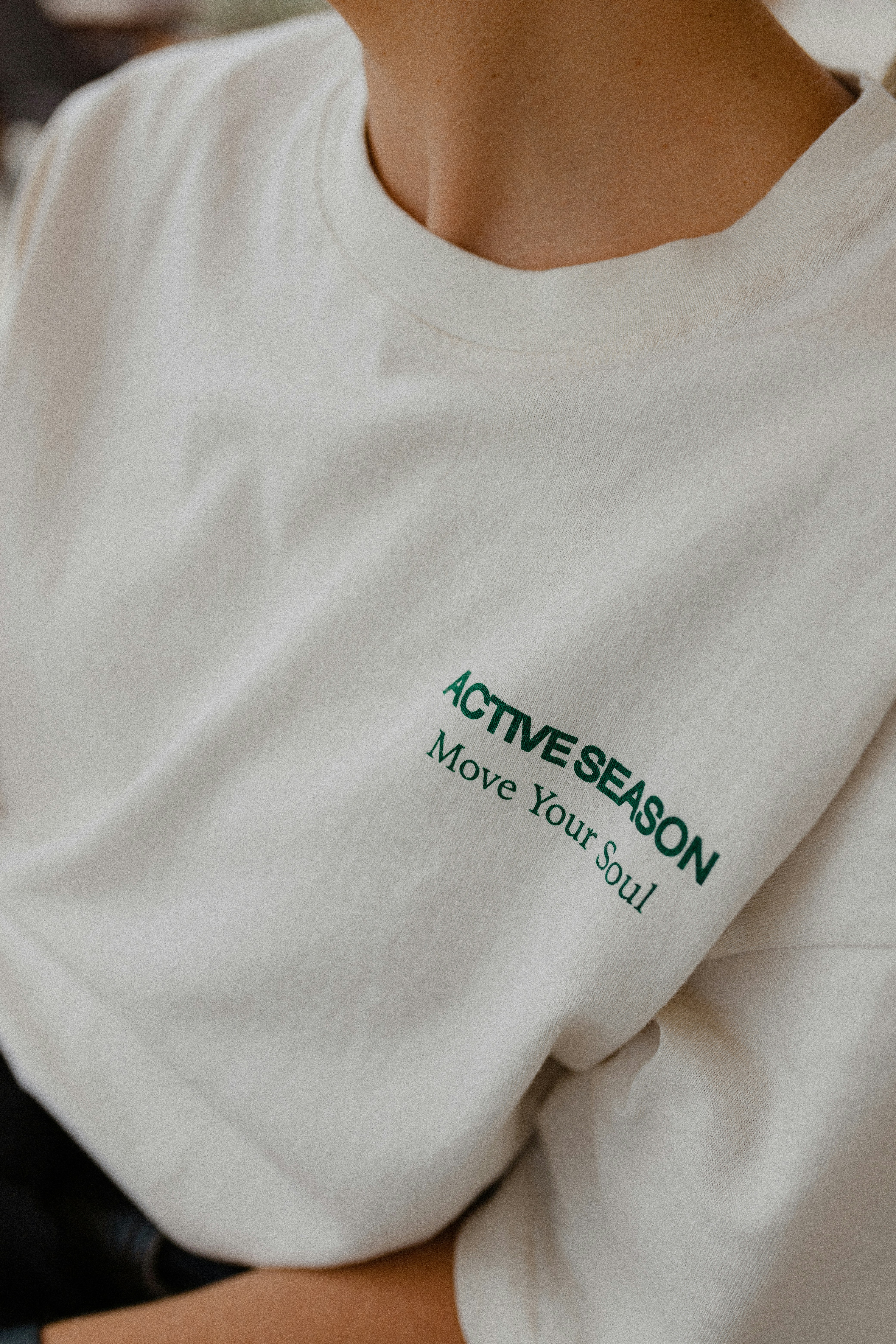 a person wearing a white shirt with green text on it