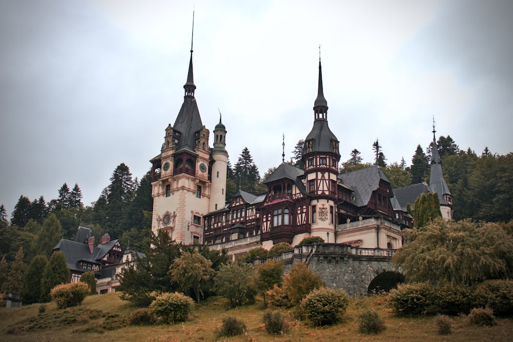 a castle with towers with Peleș Castle in the background