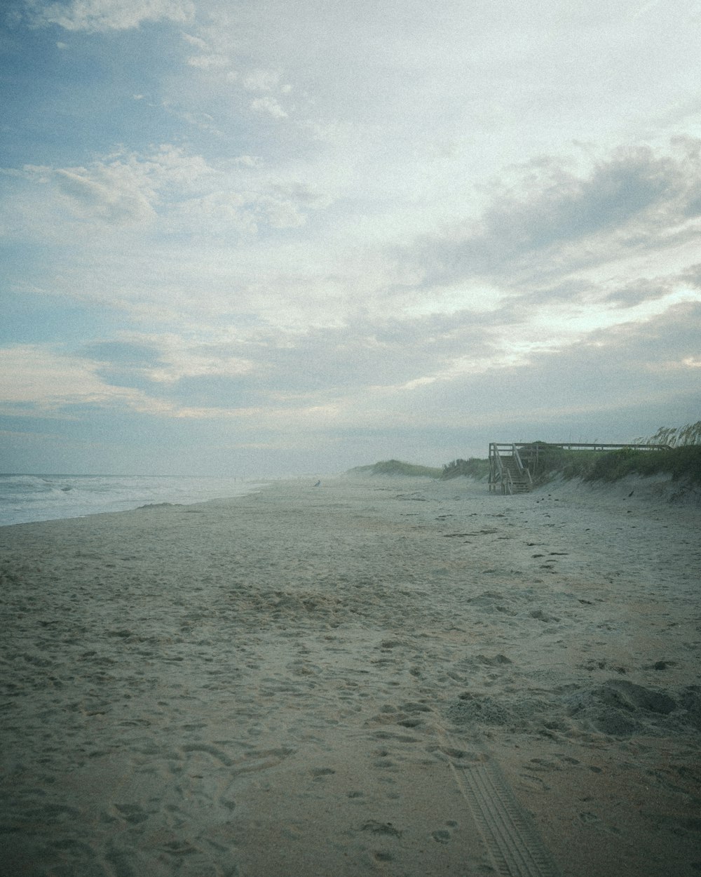 a sandy beach with a bridge