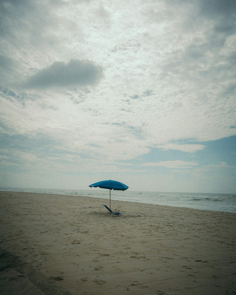 a chair and umbrella on a beach