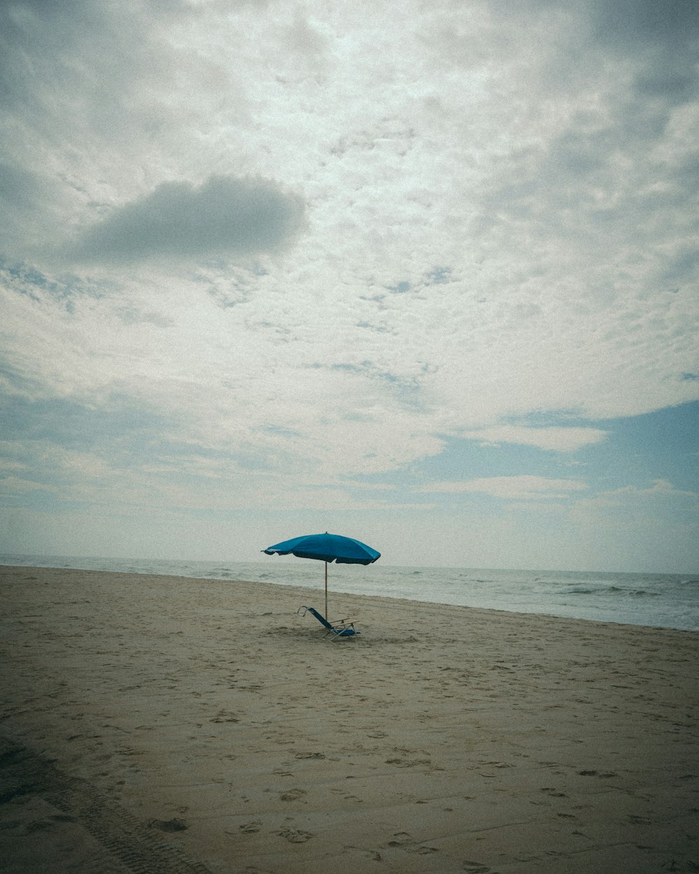uma cadeira e guarda-sol em uma praia