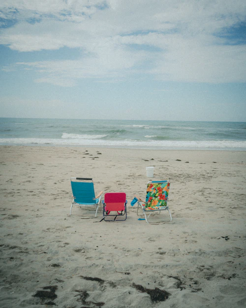 Empty beach loungers facing the ocean at sunset