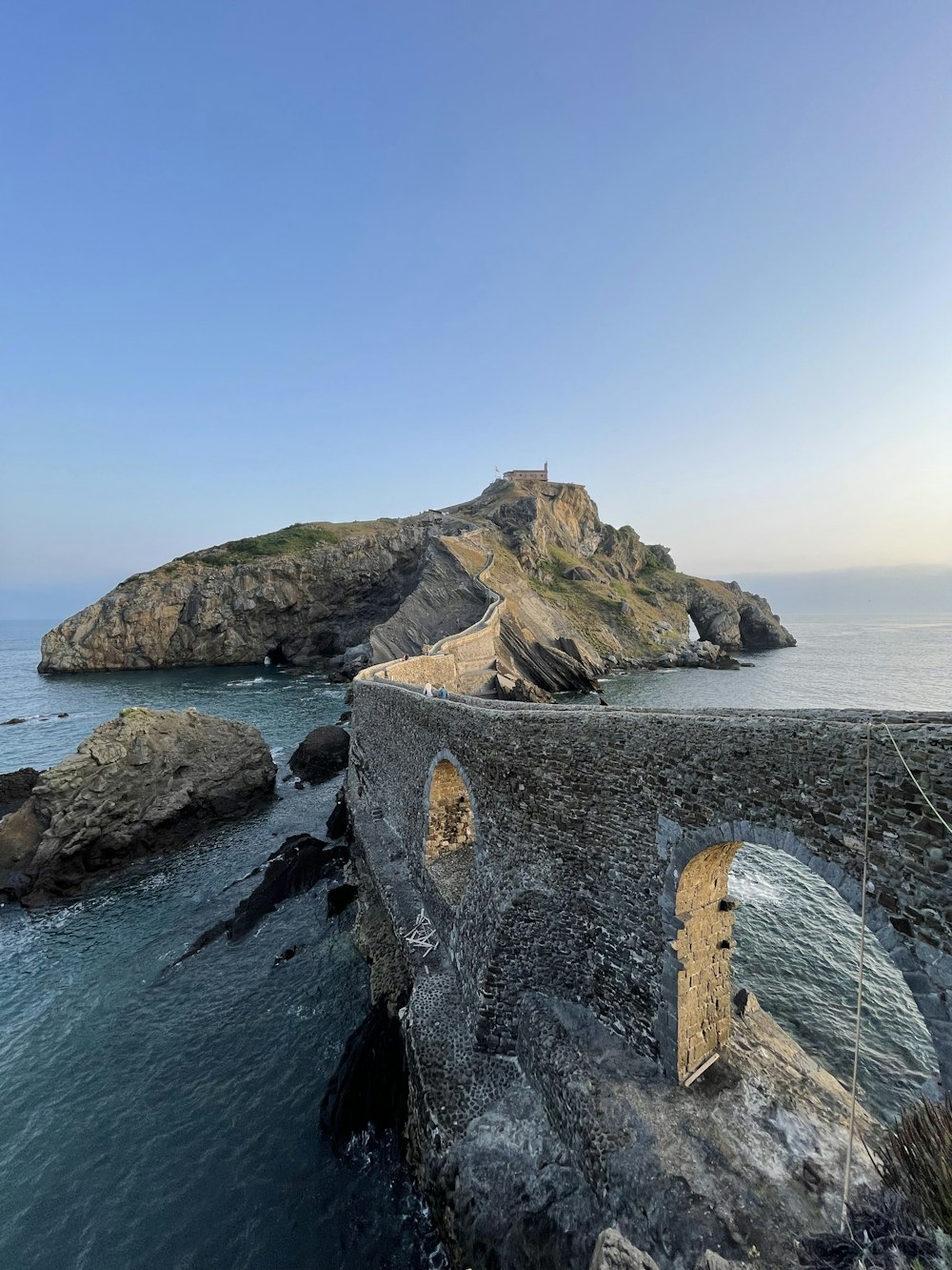 a stone structure on a cliff over the ocean