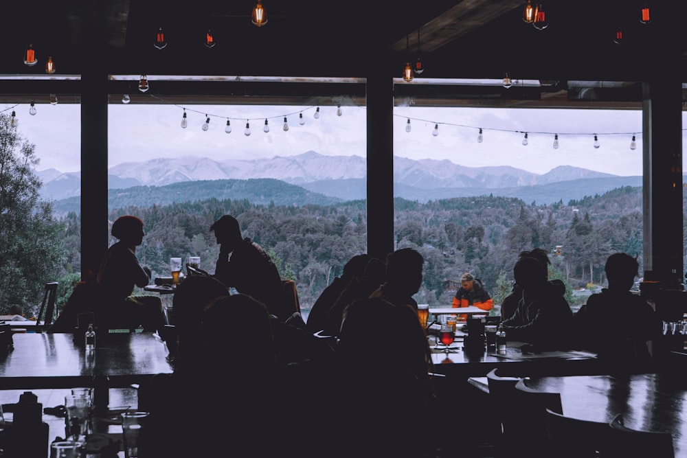 a group of people sitting at a table with a view of a mountain