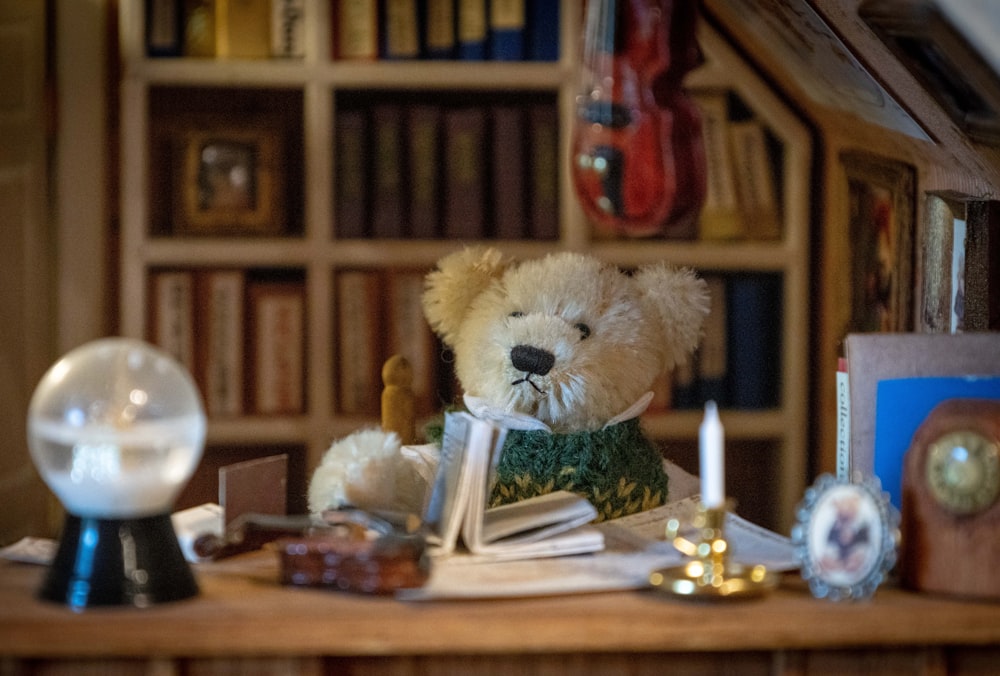 a teddy bear sits on a desk