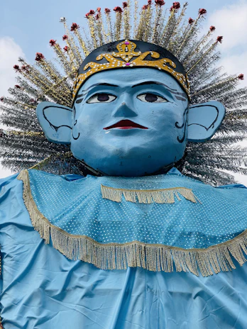 A regal portrait of King Kosoko in traditional Yoruba royal attire, set against a deep royal blue background with antique gold accents.