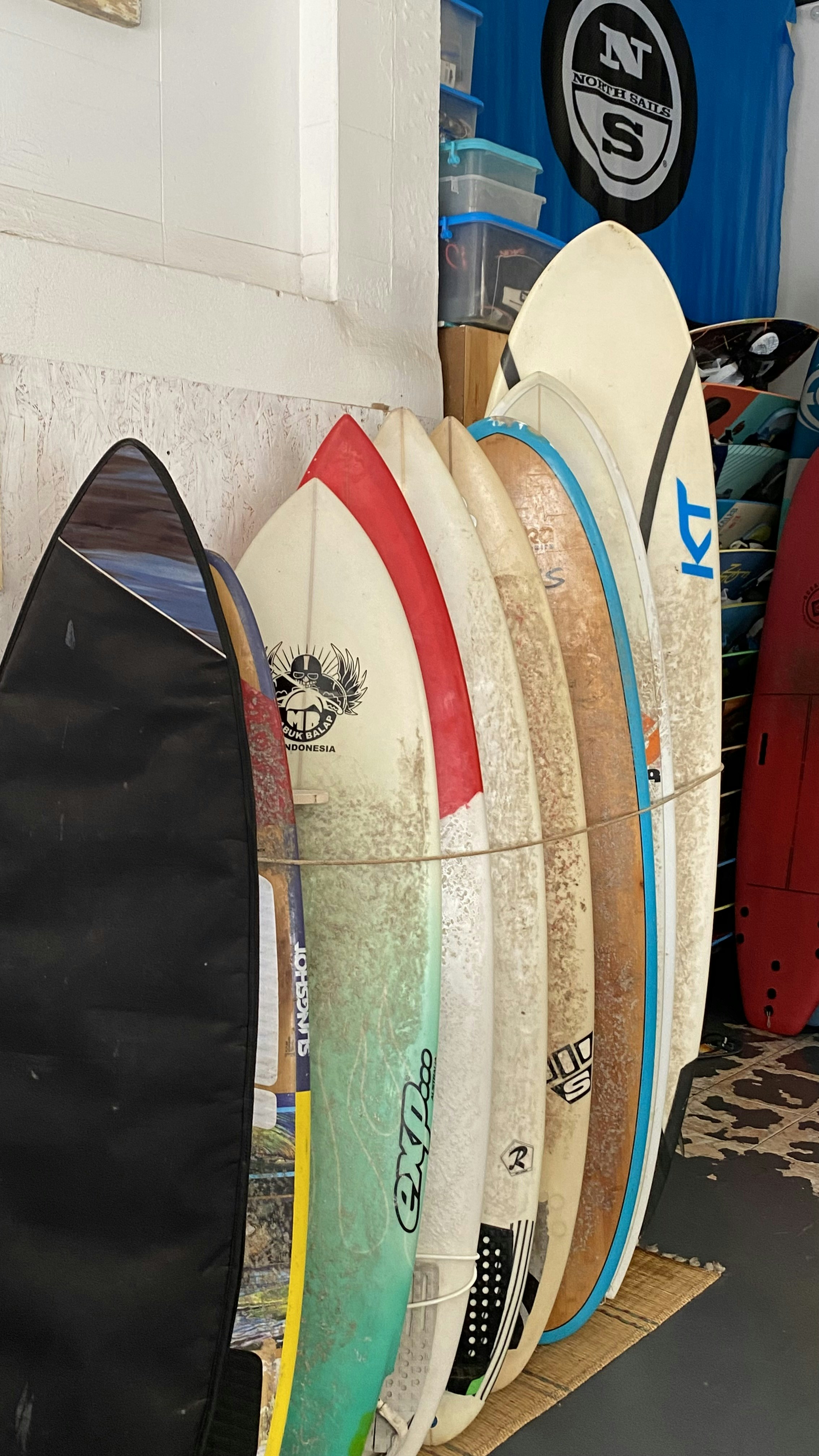 a group of surfboards next to a wall