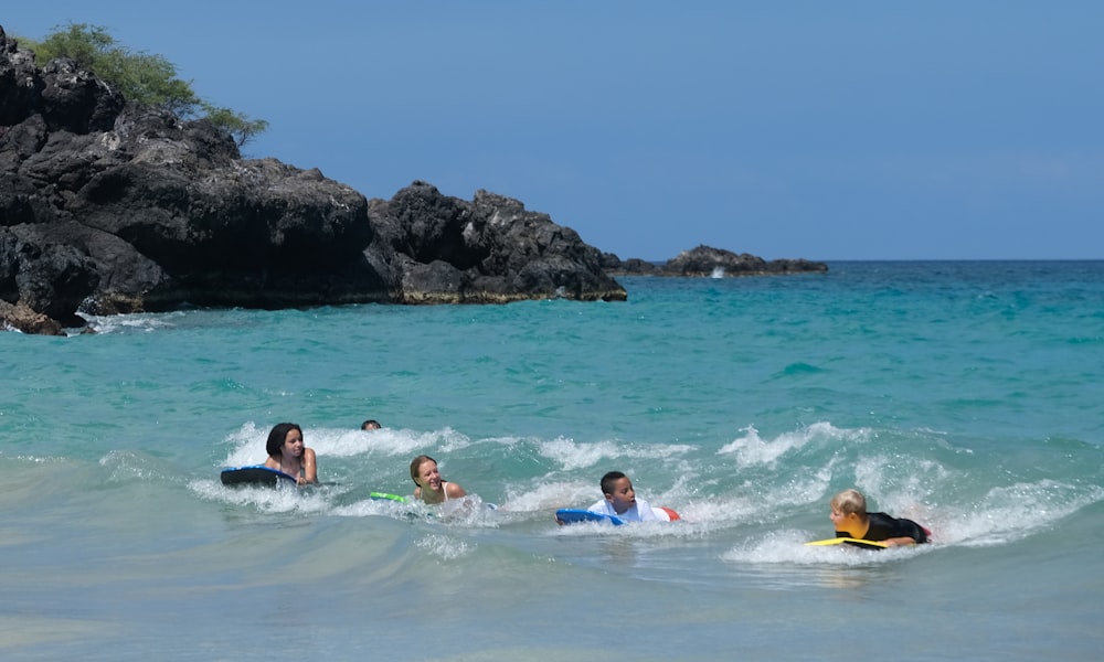 a group of people surfing in the sea