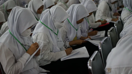 a group of people in white lab coats working on a computer