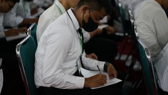 a man writing on a piece of paper