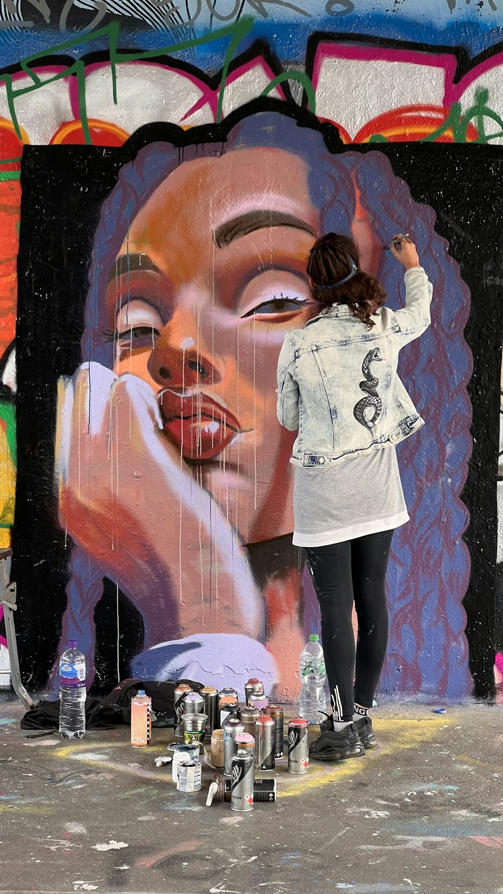 a person standing in front of a wall with graffiti