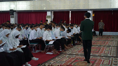 a person standing in front of a group of people sitting in chairs
