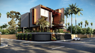 A modern, angular house with a sleek design, featuring a mix of glass, wood, and concrete materials. It is surrounded by tall palm trees and lush greenery, located at the corner of a street with a sports car parked nearby.