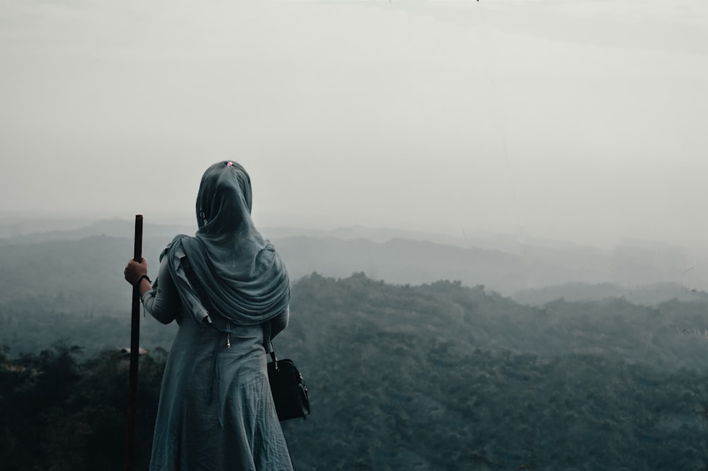 a man with a headscarf and a headscarf holding a gun in a foggy