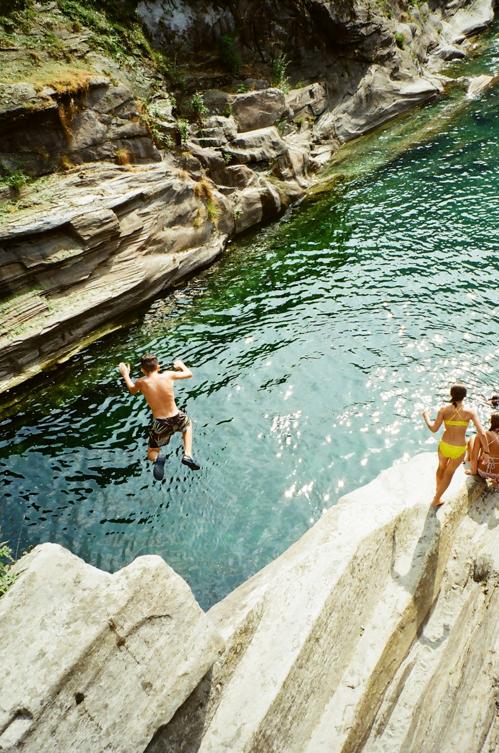 people jumping into a river