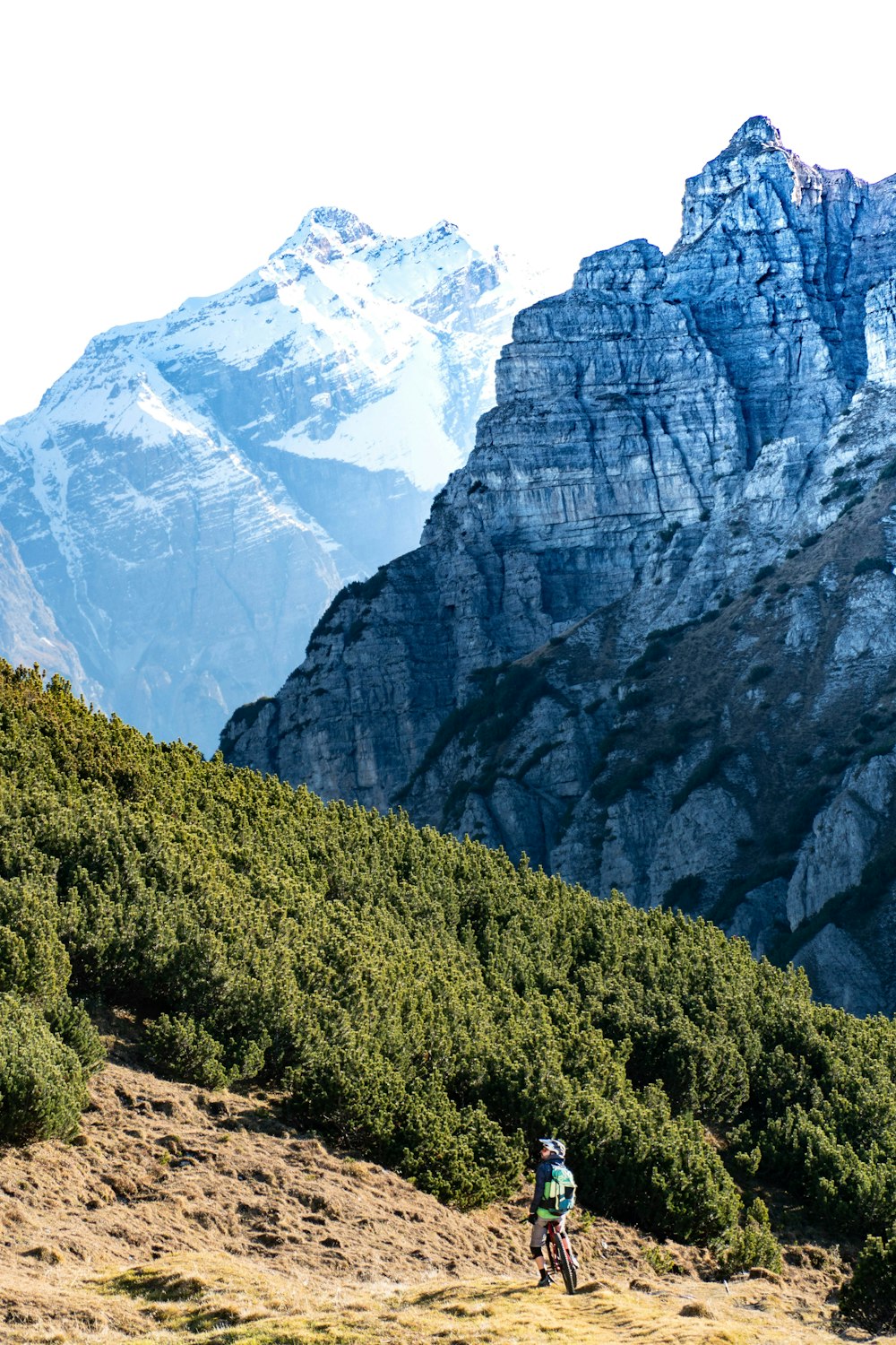 a person riding a bike on a dirt trail in front of a mountain