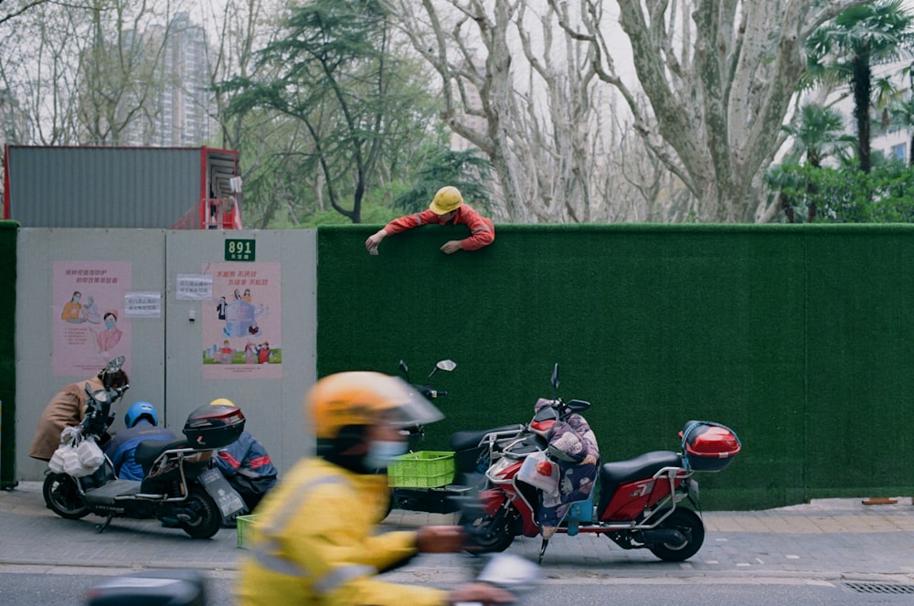 a person in a yellow jacket jumping over a motorcycle