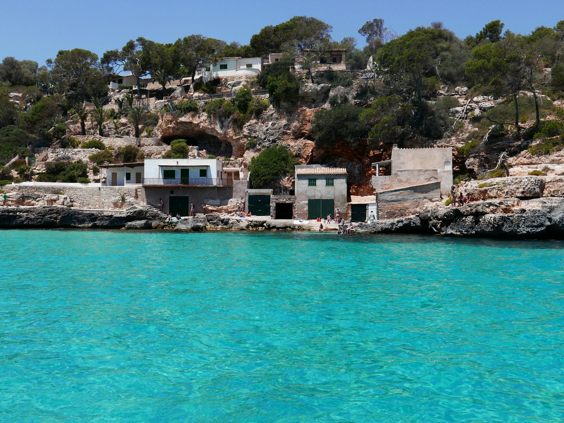 a group of houses on a rocky hillside by the water