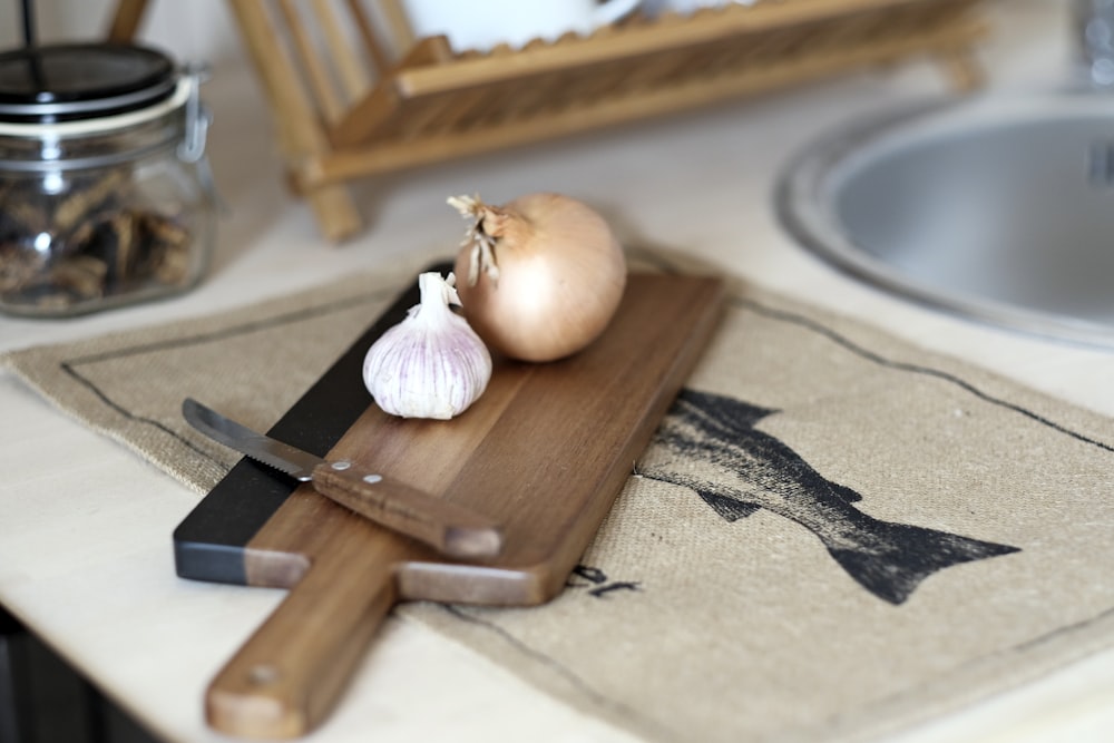 a knife and a garlic on a cutting board