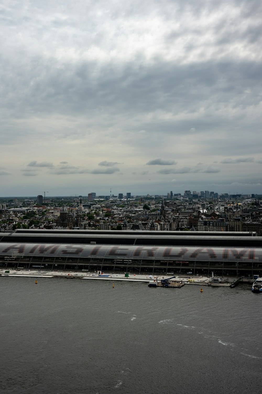 a body of water with boats in it and a city in the background