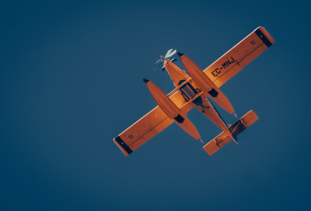 an orange and white airplane in the sky