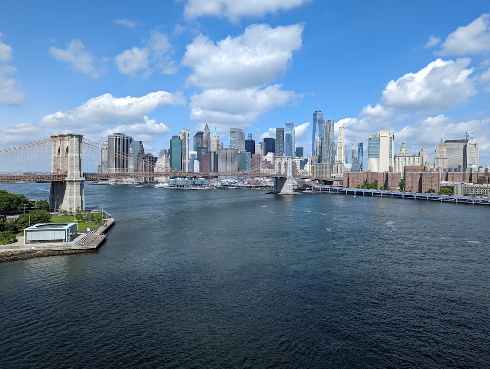 a bridge over a body of water with a city in the background