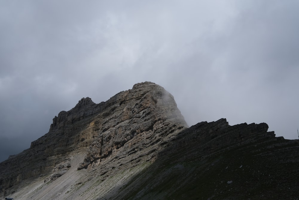 Una montaña rocosa con un cielo nublado