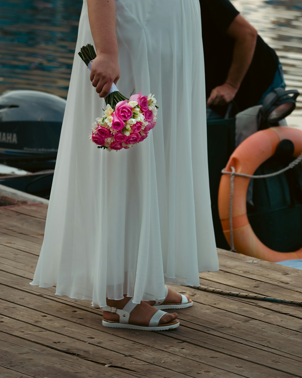 a person in a white dress holding a bouquet of flowers
