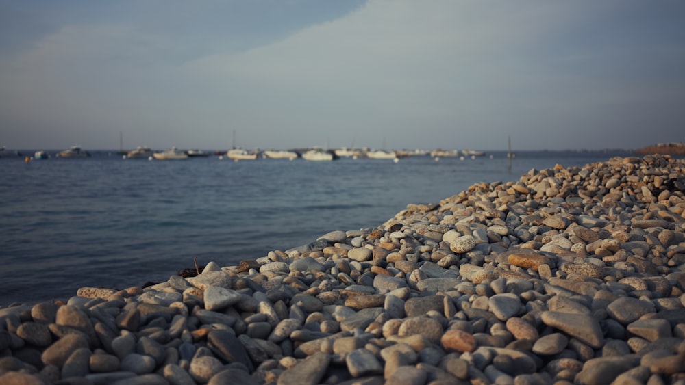 a rocky beach with boats in the water