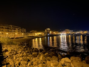 Cozy hotel exterior illuminated by warm evening lights near the shoreline.