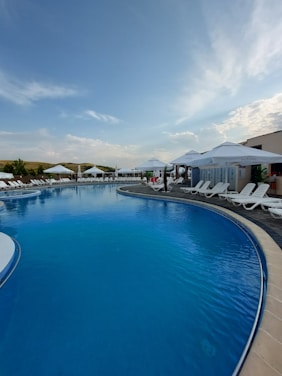 A serene swimming pool with clear blue water reflecting sunlight.