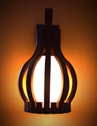 Artistic wall sconces with minimalist design glowing softly against a neutral wall.