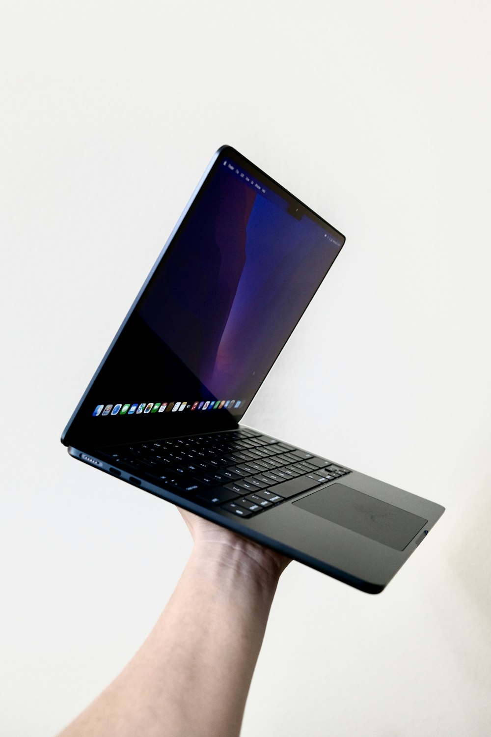 una mano che tiene un computer portatile