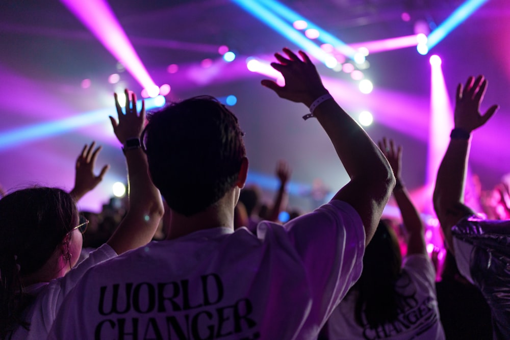 a group of people with their hands up in the air