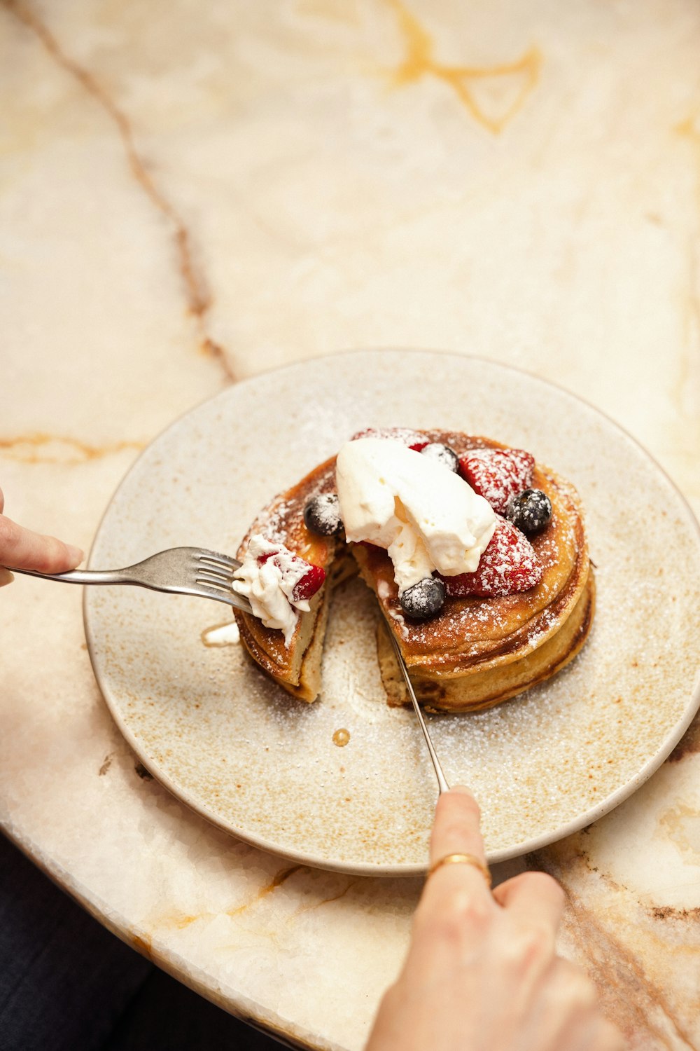 a plate of pancakes with whipped cream and chocolate syrup