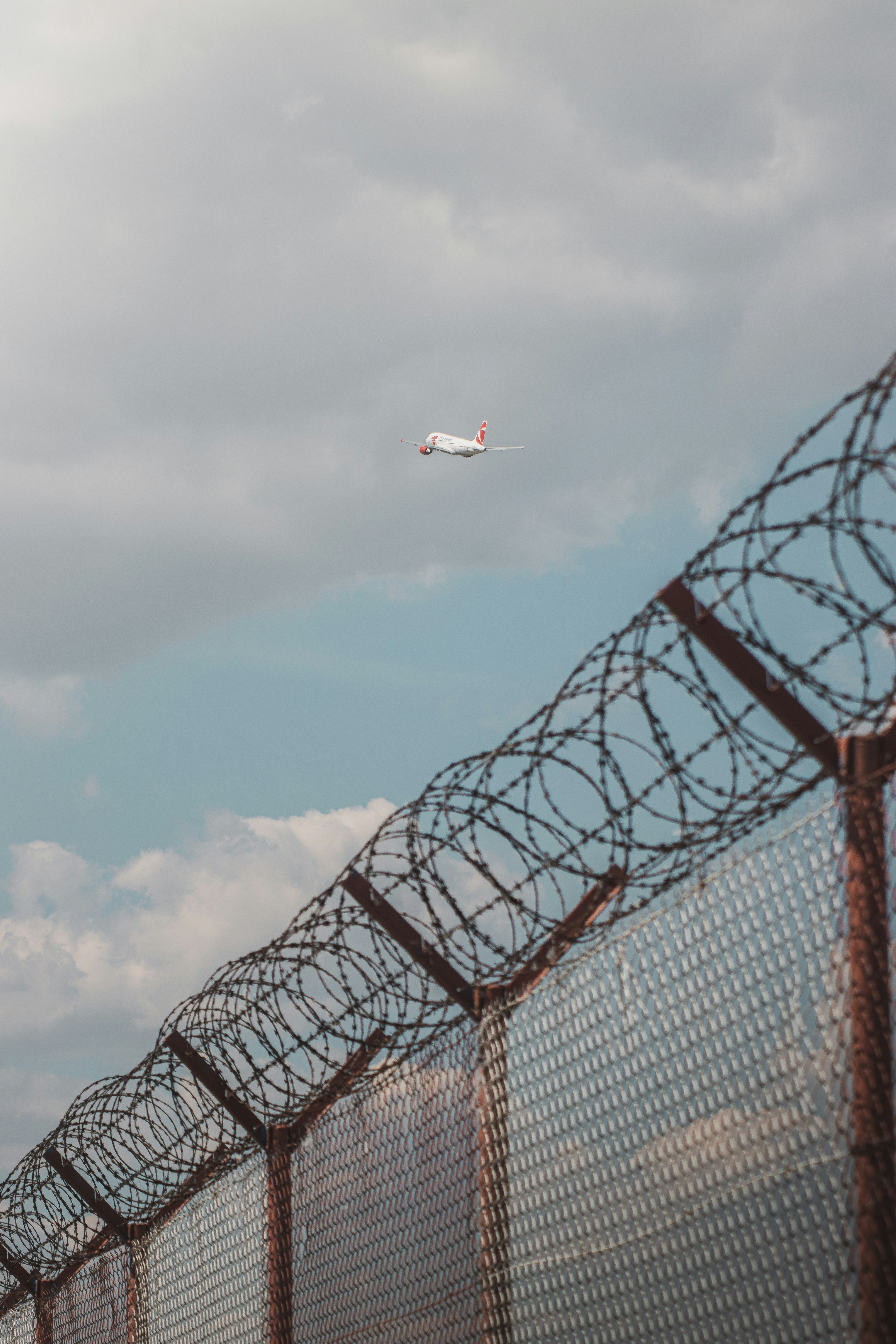 an airplane flying over a fence