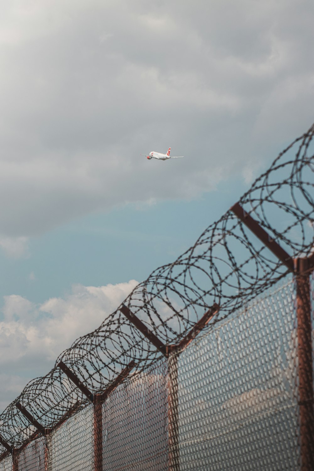 an airplane flying over a fence