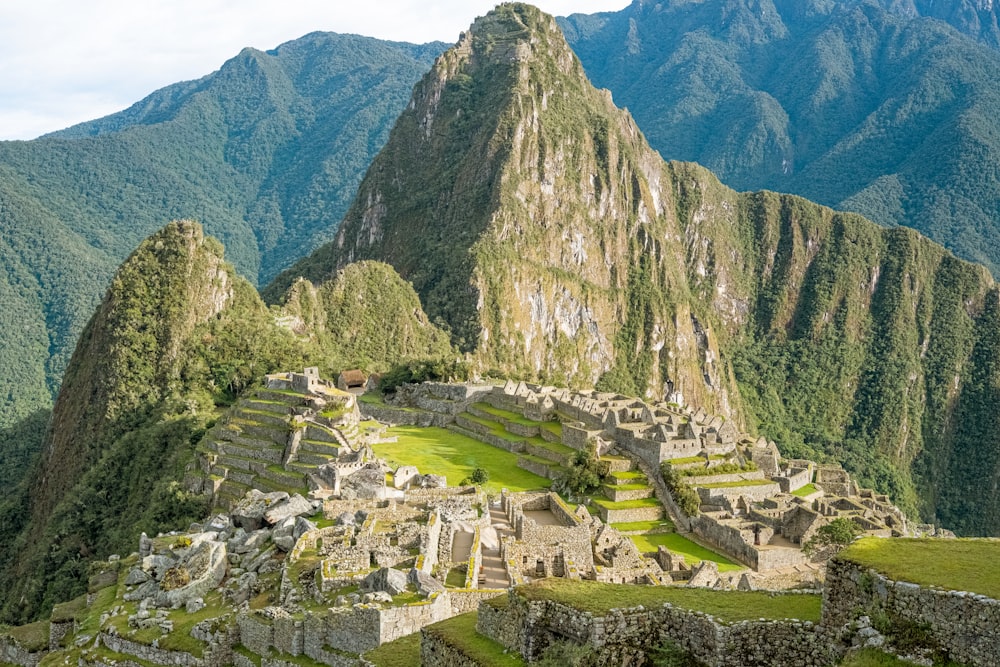 a large stone structure in the mountains with Machu Picchu in the background