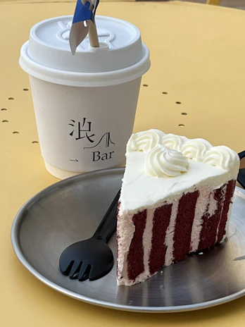 A red velvet cake slice on a pastel plate, with a handwritten note beside it adding a personal touch.