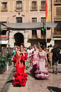 a group of people in clothing walking down a street