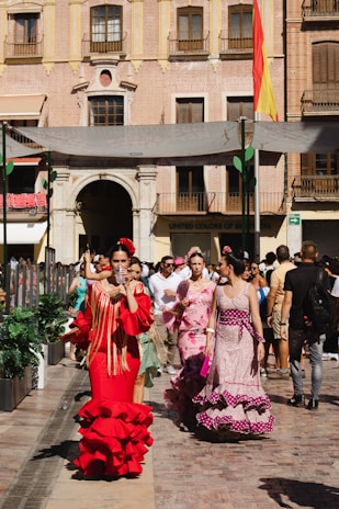 a group of people in clothing walking down a street
