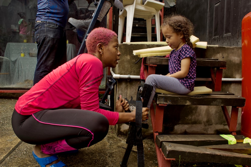 a person and a child sitting on a bench