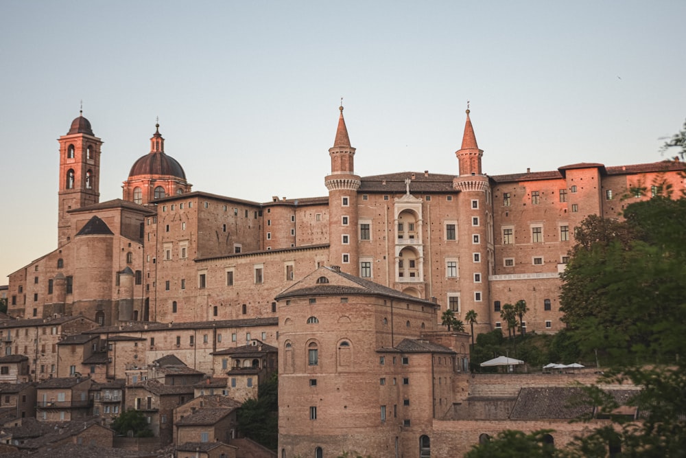un grande edificio con una cupola in cima con Urbino sullo sfondo