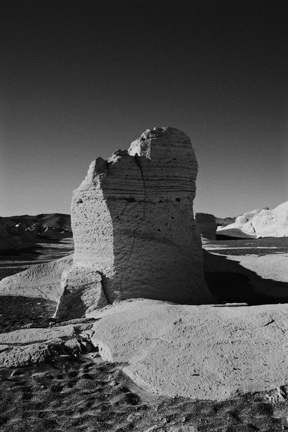 a large rock in the middle of a desert