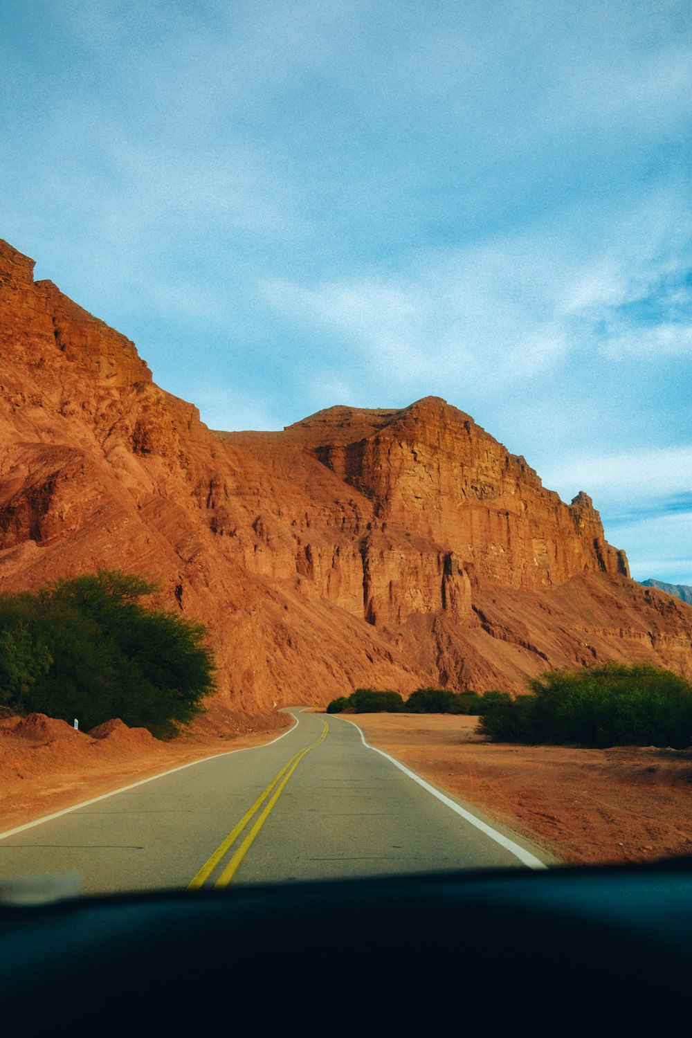 a road with a large rock cliff