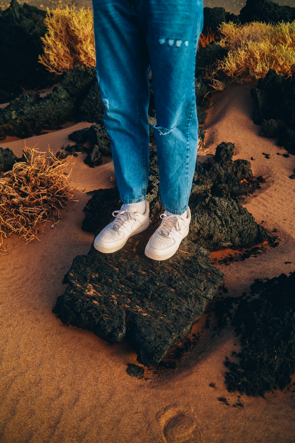 Die Beine und Füße einer Person auf einem Felsen