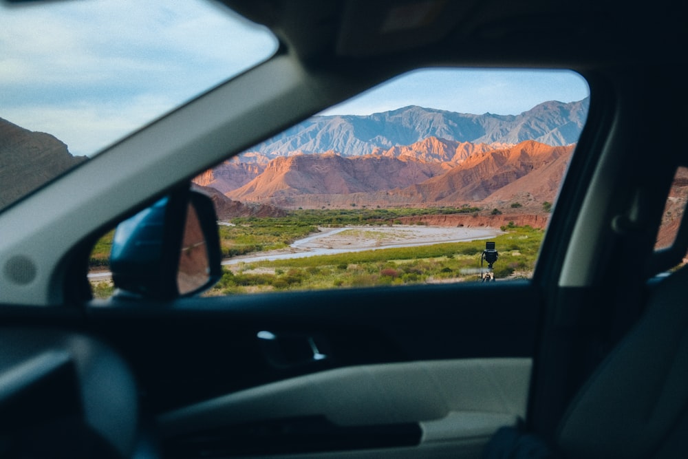 a view of a mountain range from inside a car