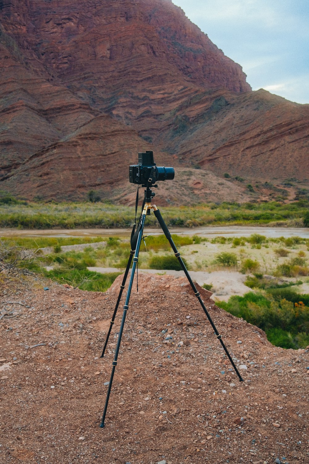 a camera on a tripod in front of a mountain